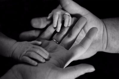 Child's hands on top of adult hands