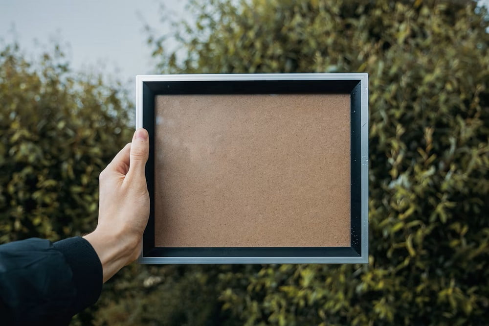Hand holding a blank photo frame