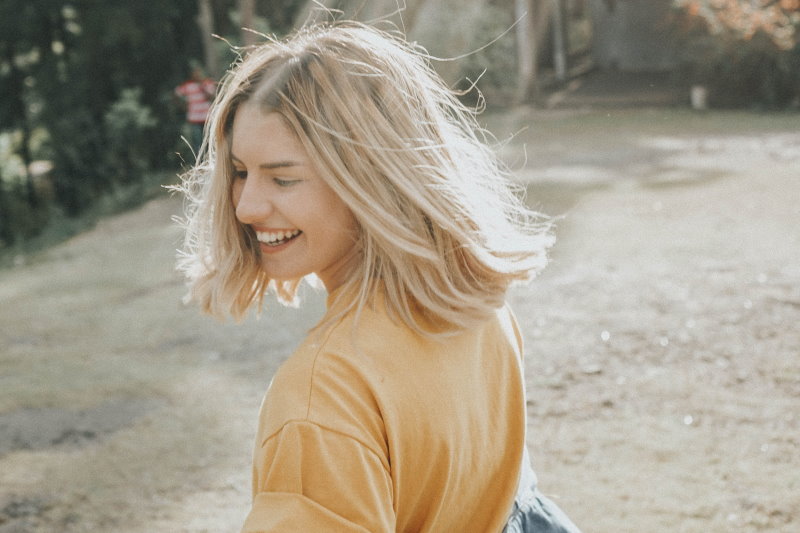 Blonde woman looking over her shoulder and smiling
