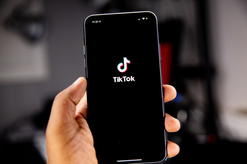 Person holding an iPhone in their hand with the TikTok app open