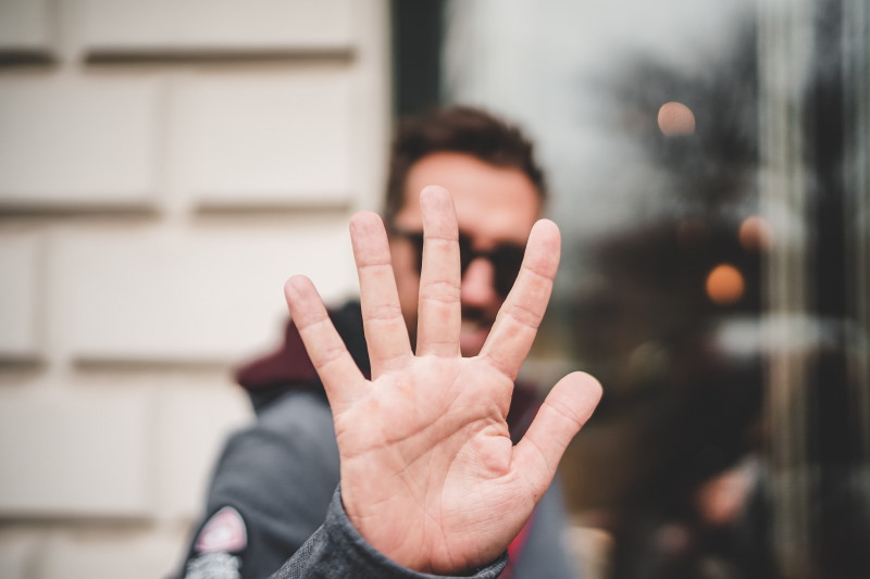 Blurred focus picture of a man holding up his right hand